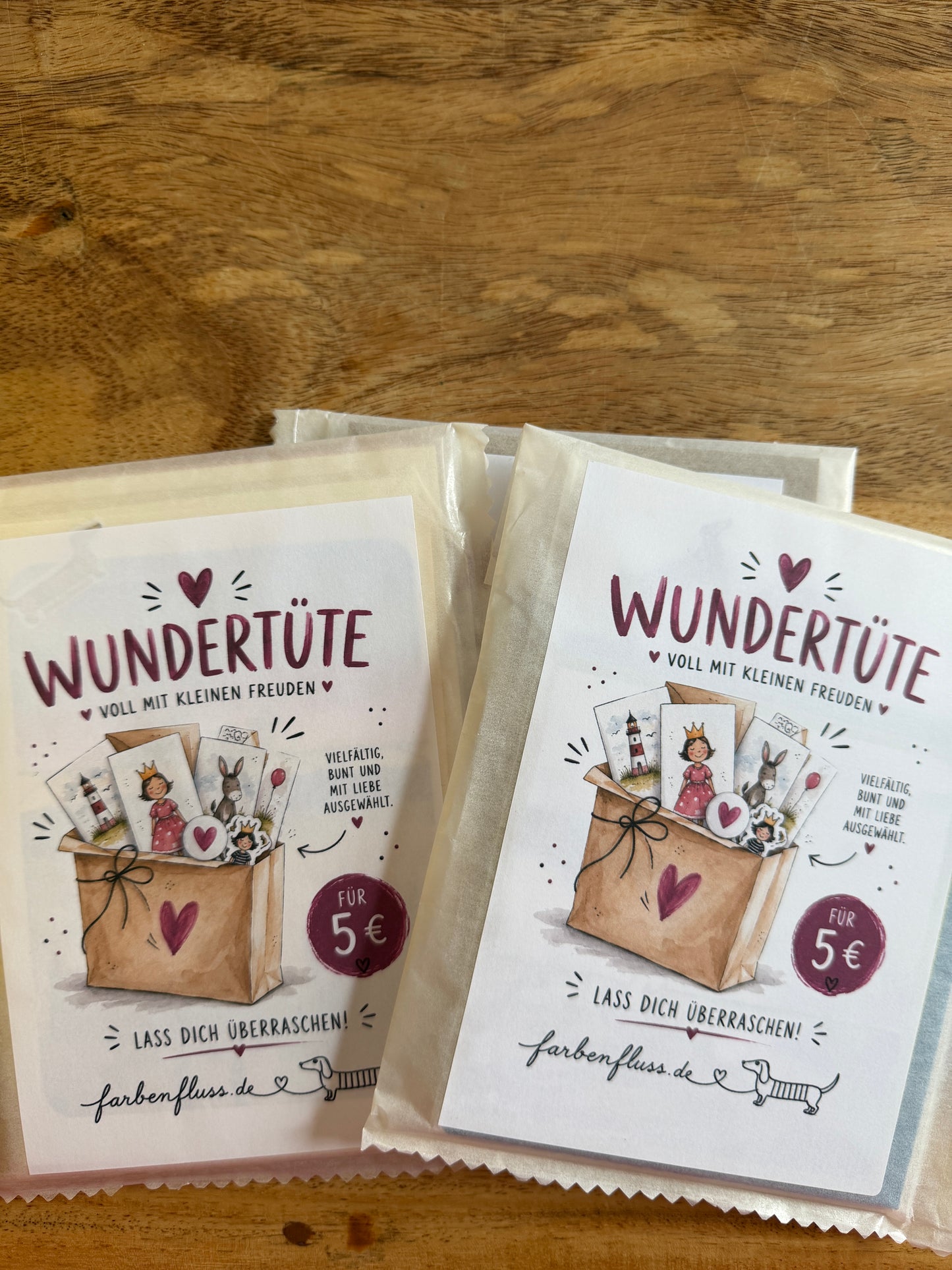 Mehrere farbenfluss-Wundertüten mit drei Klappkarten, einer Postkarte und möglichen Extras